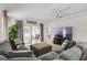 Inviting living room featuring a comfortable sectional sofa, modern entertainment center, and access to outdoor space at 2012 Braxton St, Clermont, FL 34711