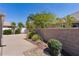 Landscaped backyard with stone wall, concrete, decorative rocks, and healthy green trees at 2026 Altamonte Way, The Villages, FL 32162