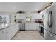 Spacious kitchen featuring white cabinets, granite countertops, stainless steel appliances, and tile flooring at 2026 Altamonte Way, The Villages, FL 32162