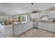 Open kitchen showcases white cabinetry, granite countertops, and stainless steel appliances, seamlessly flowing into the living area at 2026 Altamonte Way, The Villages, FL 32162