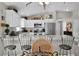 Bright kitchen boasts white cabinets, stainless steel appliances, and stylish bar seating at the large countertop at 2026 Altamonte Way, The Villages, FL 32162