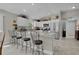 Well-lit kitchen with white cabinets, stainless steel appliances, and a large counter with barstool seating at 2026 Altamonte Way, The Villages, FL 32162