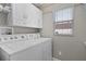 Laundry room with a washer, dryer, and white cabinets at 2026 Altamonte Way, The Villages, FL 32162