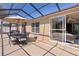 Screened-in patio with dining set, outdoor umbrella, and seamless access to indoor living space at 2026 Altamonte Way, The Villages, FL 32162