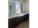 Modern bathroom featuring dual sinks with white countertops and dark wood cabinetry at 2048 Airedale Way, Lake Alfred, FL 33850