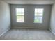 Bright bedroom featuring plush carpeting, neutral walls, and a dual window setup for ample natural light at 2048 Airedale Way, Lake Alfred, FL 33850