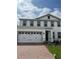 Two-story home featuring a three-car garage and brick-paved driveway at 2048 Airedale Way, Lake Alfred, FL 33850