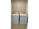Laundry area equipped with a modern washer and dryer and a wire rack for storage at 2048 Airedale Way, Lake Alfred, FL 33850