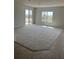 Spacious living room with large sliding glass doors, plush carpeting, and neutral walls at 2048 Airedale Way, Lake Alfred, FL 33850