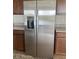 Side-by-side stainless steel refrigerator in kitchen with brown cabinets at 2048 Airedale Way, Lake Alfred, FL 33850
