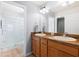 Bathroom featuring double sinks, wood cabinets, a walk-in shower and wood floors at 2104 Iveywood St, The Villages, FL 32163