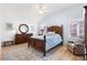 A bedroom with a wooden bed, hardwood floors, dresser and natural light at 2104 Iveywood St, The Villages, FL 32163