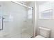 A sleek and modern walk-in shower with glass door, toilet and a window at 2104 Iveywood St, The Villages, FL 32163
