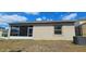 View of the backyard showcasing a screened-in porch, window, and air conditioning unit at 2129 Amor Way, Leesburg, FL 34748