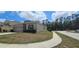 Exterior side view of home showcasing the landscaped yard, street access, and two-car garage at 2129 Amor Way, Leesburg, FL 34748