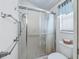 Bathroom featuring glass-enclosed shower, tile surround, updated fixtures, and decorative accents at 2256 Margarita Dr, The Villages, FL 32159