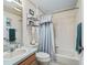 Bathroom features shower-tub combo with curtains and a sink with wood vanity and decor at 2256 Margarita Dr, The Villages, FL 32159