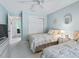 Bright bedroom features a ceiling fan, light-blue walls, two beds, and a closet at 2256 Margarita Dr, The Villages, FL 32159
