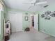 A bright bedroom featuring a ceiling fan, light-green walls, and a closet with white doors at 2256 Margarita Dr, The Villages, FL 32159