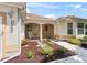 Cozy front porch features a seating area, manicured landscaping, and warm stucco exterior at 2256 Margarita Dr, The Villages, FL 32159