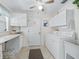 Laundry room with white cabinets, tile floor, window, and a washer and dryer set at 2256 Margarita Dr, The Villages, FL 32159
