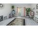 Bright, airy room featuring wood floors, decorative plants and large sliding glass doors with pink curtains at 2256 Margarita Dr, The Villages, FL 32159