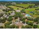 Aerial view of a community featuring the pool area, community buildings, mature trees, and green spaces at 25524 Maurepas Ln, Leesburg, FL 34748