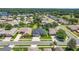 Aerial view of a home with mature landscaping in a residential area at 25524 Maurepas Ln, Leesburg, FL 34748
