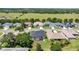 Aerial view of home near trees, landscaping, and green field at 25524 Maurepas Ln, Leesburg, FL 34748