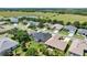 Aerial view of home with screened enclosure near green fields at 25524 Maurepas Ln, Leesburg, FL 34748