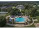 An aerial view displays a community pool, clubhouse, lush landscaping, and recreational area at 25524 Maurepas Ln, Leesburg, FL 34748