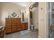 Bathroom boasts a wooden vanity, granite countertop, tiled floors, ample storage, and a glass shower at 25524 Maurepas Ln, Leesburg, FL 34748