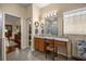 Bathroom featuring tiled floors, a granite topped vanity, a makeup vanity, and an open doorway to the Primary at 25524 Maurepas Ln, Leesburg, FL 34748