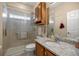 Updated bathroom with granite countertops, tiled shower with glass door, and wooden vanity at 25524 Maurepas Ln, Leesburg, FL 34748