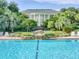 The community clubhouse overlooks a serene waterfall feature and manicured grounds at 25524 Maurepas Ln, Leesburg, FL 34748