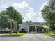 Community entrance gate with palm trees, well-maintained landscaping, and marked 'Visitors' and 'Residents' lanes at 25524 Maurepas Ln, Leesburg, FL 34748