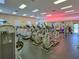 Bright fitness center featuring cardio machines, weight equipment, mirrored wall and neon 'Fitness Center' sign at 25524 Maurepas Ln, Leesburg, FL 34748