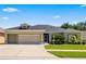 Charming single-story home with a well-manicured lawn and a two-car garage at 25524 Maurepas Ln, Leesburg, FL 34748