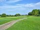 Lush green golf course with a winding path and mature trees, perfect for a leisurely game at 25524 Maurepas Ln, Leesburg, FL 34748