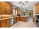 Well-lit kitchen with stainless steel appliances, wood cabinetry, and a breakfast nook with backyard views at 25524 Maurepas Ln, Leesburg, FL 34748