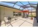 Relaxing screened lanai with a dining table, chairs, and a large outdoor living area at 25524 Maurepas Ln, Leesburg, FL 34748