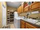 Bright laundry room with washer, dryer, sink, cabinets, shelving, and a door to the backyard at 25524 Maurepas Ln, Leesburg, FL 34748