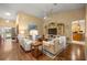 Open-concept living room with vaulted ceilings, hardwood floors, and entertainment center at 25524 Maurepas Ln, Leesburg, FL 34748