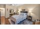 The bedroom features hardwood floors, a comfortable bed with blue accents, and mirrored closet doors at 25524 Maurepas Ln, Leesburg, FL 34748