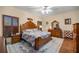 Comfortable bedroom features hardwood floors, a ceiling fan, and a decorative headboard at 25524 Maurepas Ln, Leesburg, FL 34748
