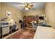 Home office with a ceiling fan, a large window, and a patterned area rug at 25524 Maurepas Ln, Leesburg, FL 34748
