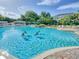 Inviting community pool offers a refreshing escape, complemented by ample seating and lush greenery at 25524 Maurepas Ln, Leesburg, FL 34748