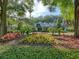 Charming restaurant with lush landscaping, colorful flower beds, and a welcoming entrance at 25524 Maurepas Ln, Leesburg, FL 34748