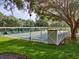 Community shuffleboard court featuring shaded seating and pristine green grass at 25524 Maurepas Ln, Leesburg, FL 34748