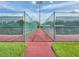 View between tennis courts behind green fencing that is set up for games at 25524 Maurepas Ln, Leesburg, FL 34748
